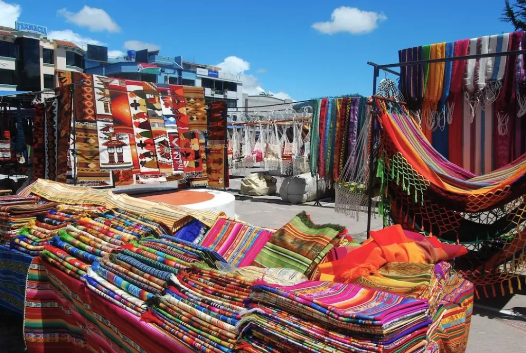 Feria en la Plaza de Ponchos de Otavalo con artesanías y productos locales
